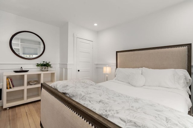 bedroom with a wainscoted wall, recessed lighting, and wood finished floors