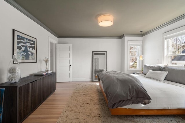 bedroom featuring light wood-type flooring and crown molding