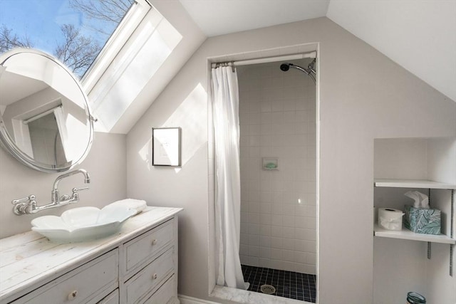 bathroom with lofted ceiling, vanity, and a shower stall