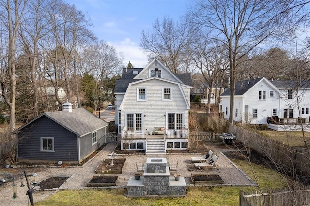 back of house featuring a deck, a vegetable garden, fence, and a shingled roof