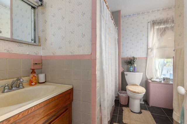 bathroom featuring toilet, tile patterned flooring, vanity, curtained shower, and tile walls