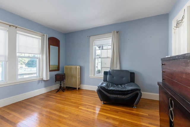 sitting room featuring radiator heating unit and light wood-type flooring