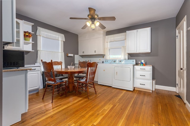 laundry area featuring ceiling fan, washing machine and clothes dryer, and light hardwood / wood-style flooring