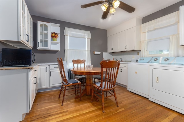 interior space featuring washer and dryer, ceiling fan, and light hardwood / wood-style floors