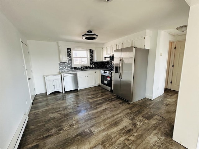 kitchen with dark wood-style floors, tasteful backsplash, appliances with stainless steel finishes, a baseboard heating unit, and white cabinets