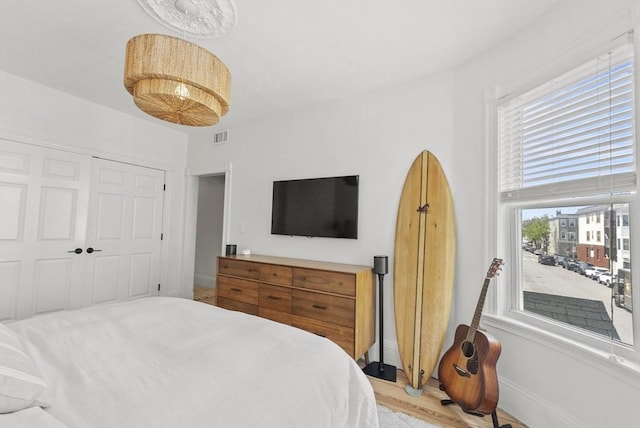 bedroom with light wood-style flooring and a closet