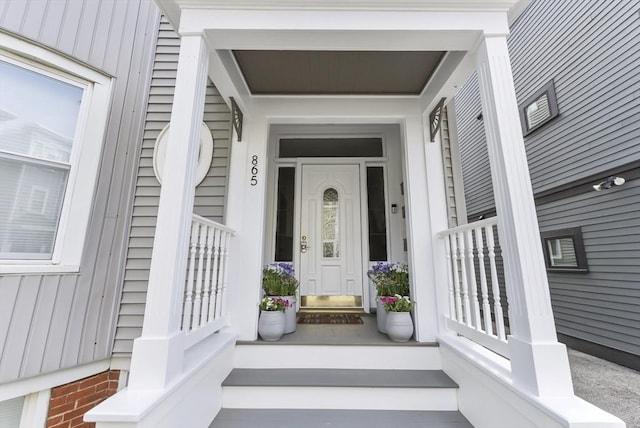 doorway to property with covered porch and board and batten siding