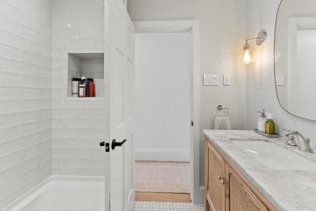 full bath with vanity, baseboards, a bath, and a shower
