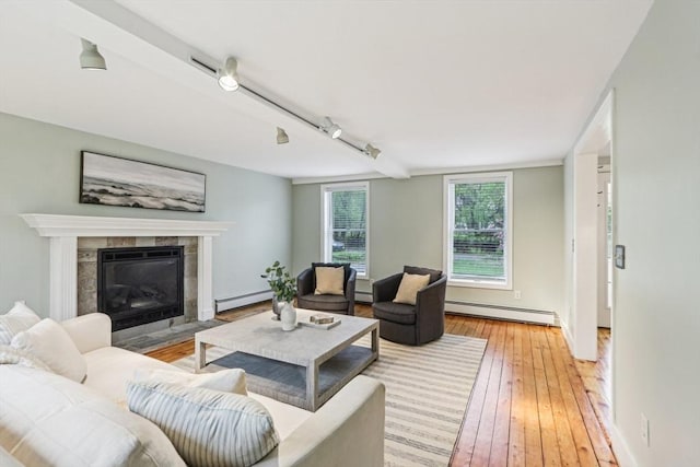 living room featuring light wood-style floors, a baseboard radiator, baseboard heating, and a fireplace