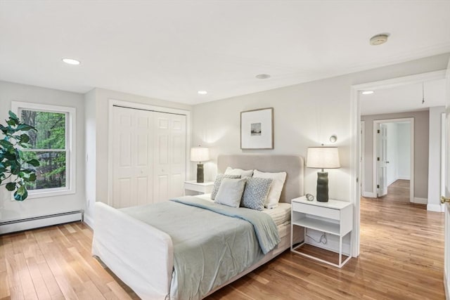 bedroom featuring light wood finished floors, baseboards, baseboard heating, and recessed lighting