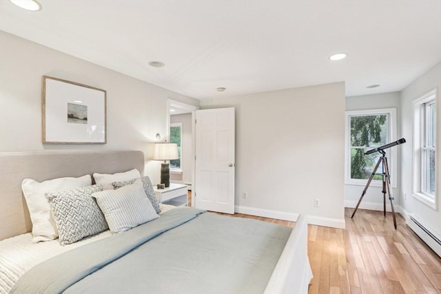 bedroom with light wood finished floors, recessed lighting, baseboards, and a baseboard heating unit