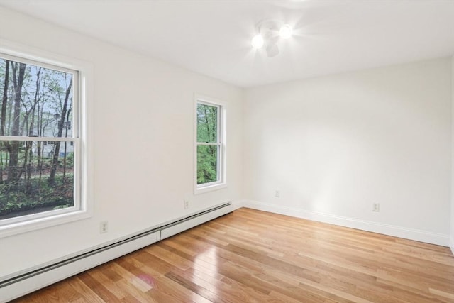 unfurnished room with light wood finished floors, baseboards, and baseboard heating