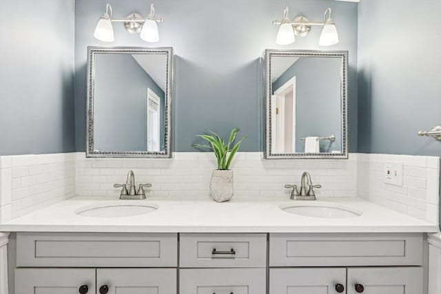 full bathroom featuring a sink, double vanity, and backsplash