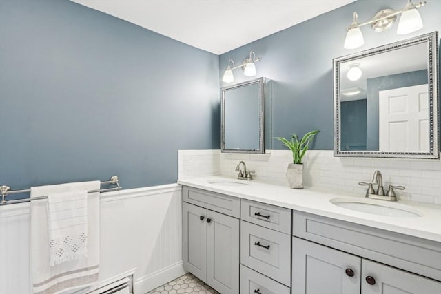 full bathroom featuring a wainscoted wall, tasteful backsplash, and a sink
