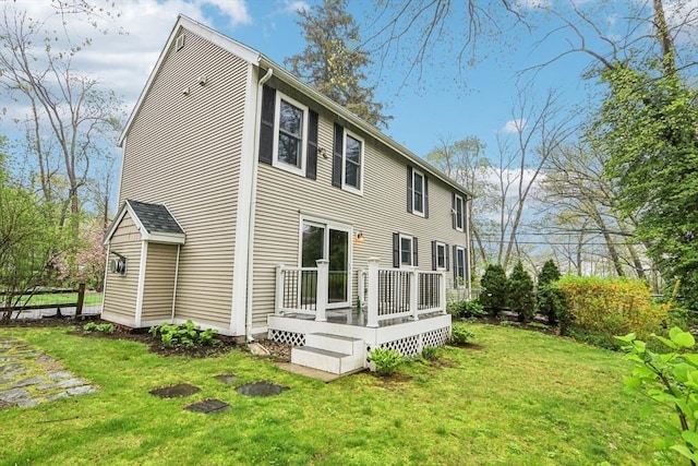 back of house featuring a lawn, a wooden deck, and fence