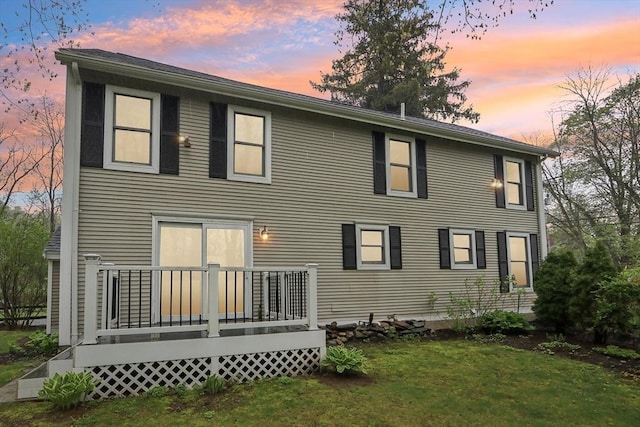 rear view of property with a yard and a wooden deck