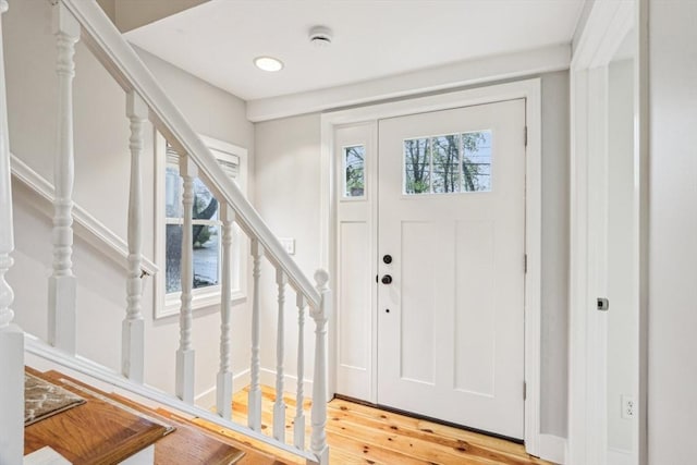 foyer featuring stairway, light wood finished floors, and recessed lighting