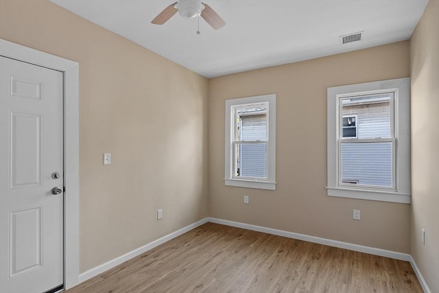 unfurnished room with light wood-type flooring, visible vents, baseboards, and a ceiling fan