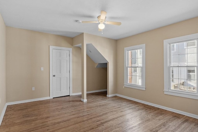 bonus room with a wealth of natural light, baseboards, and wood finished floors