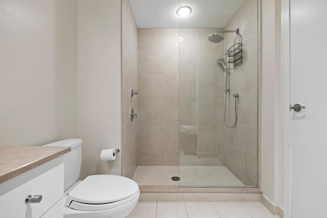 bathroom featuring tiled shower, toilet, tile patterned floors, and vanity