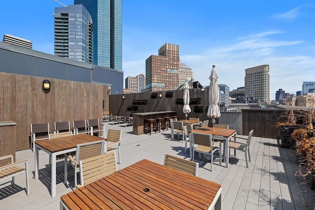 wooden deck with outdoor dining area and a view of skyline