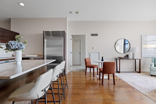 dining space with light wood-style floors, recessed lighting, and baseboards