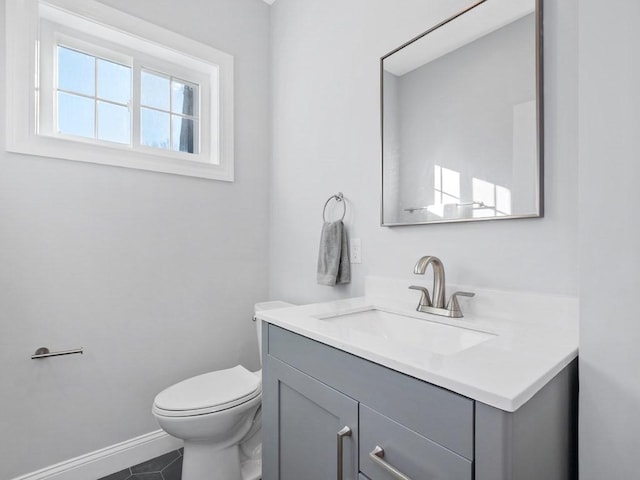 bathroom featuring toilet, vanity, and tile patterned flooring