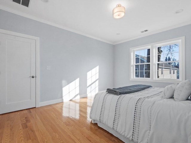 bedroom featuring light wood-type flooring and ornamental molding