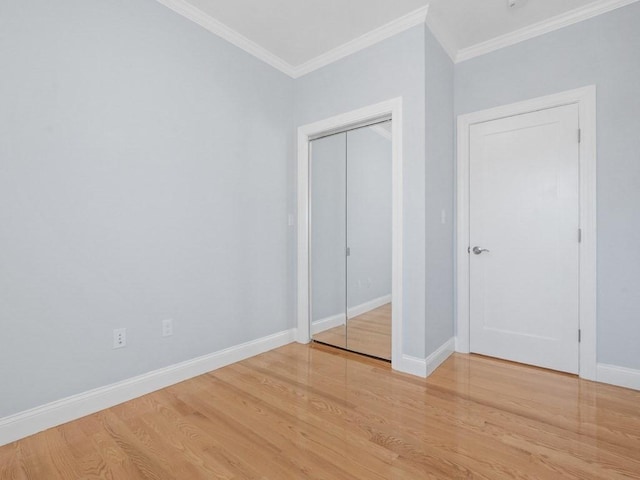 unfurnished bedroom with a closet, ornamental molding, and hardwood / wood-style flooring