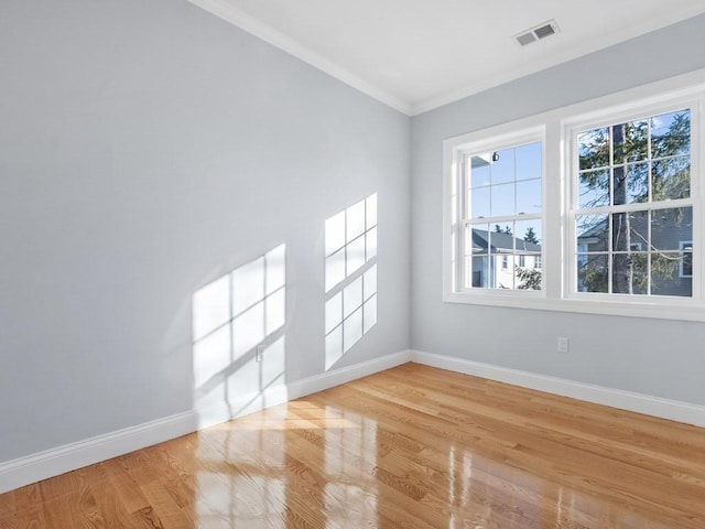 spare room featuring light wood-type flooring and ornamental molding