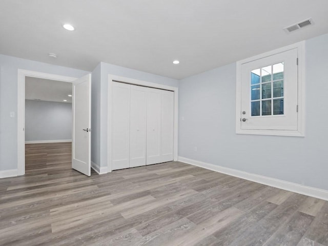 unfurnished bedroom featuring light wood-type flooring and a closet