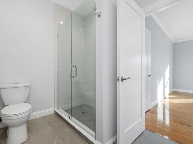 bathroom featuring toilet, crown molding, tile patterned floors, and walk in shower