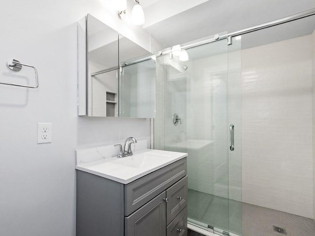 bathroom with vanity and a shower with door