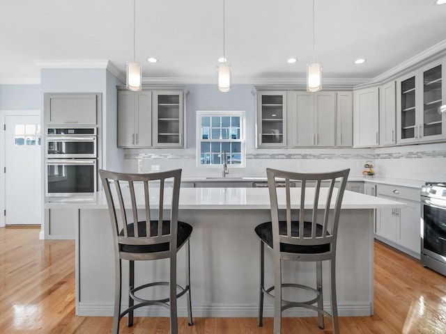 kitchen with a kitchen island, gray cabinetry, and hanging light fixtures