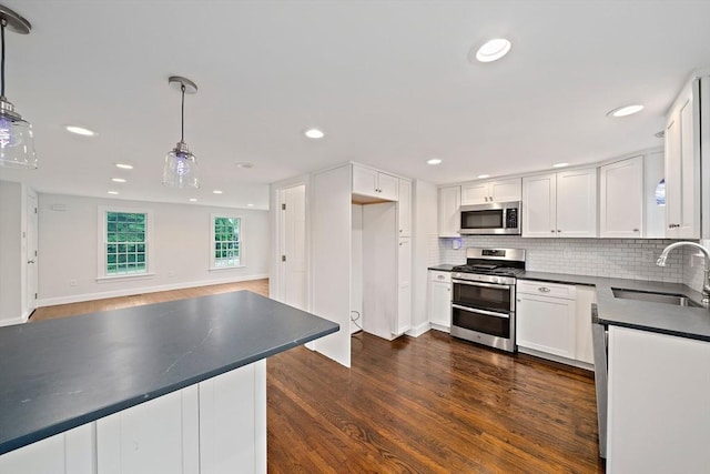 24 Summer St Unit A, Kingston, MA 02364 - kitchen with stainless steel appliances, dark countertops, dark wood finished floors, backsplash, and white cabinetry