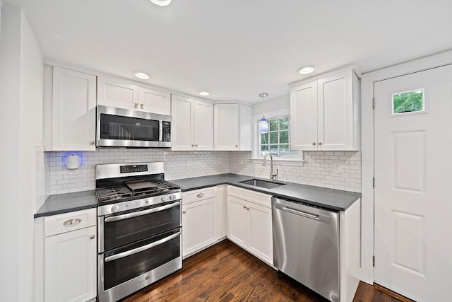 24 Summer St Unit A, Kingston, MA 02364 - kitchen with stainless steel appliances, dark countertops, white cabinets, dark wood finished floors, and tasteful backsplash