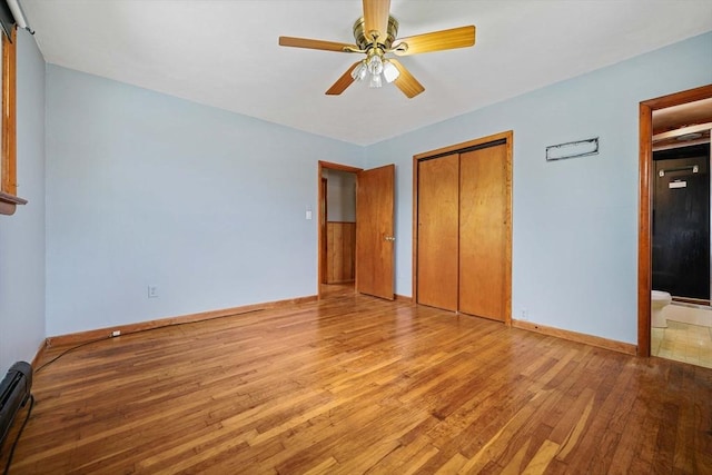20 Roy St, Fairhaven, MA 02719 - unfurnished bedroom featuring wood finished floors, a baseboard heating unit, a closet, baseboards, and connected bathroom