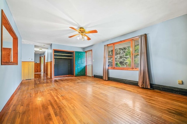 20 Roy St, Fairhaven, MA 02719 - unfurnished living room with wood-type flooring, a ceiling fan, a wainscoted wall, and wooden walls
