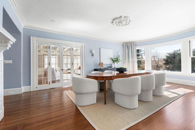 dining space featuring baseboards, ornamental molding, dark wood-type flooring, and french doors