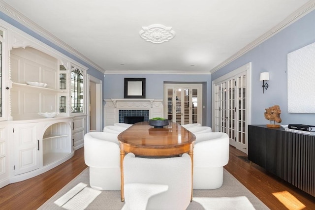 interior space with dark wood-style floors, french doors, a tile fireplace, and crown molding