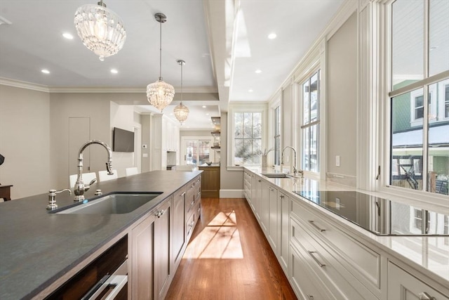 kitchen with hanging light fixtures, dark countertops, and a sink