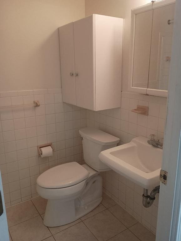 bathroom with tile patterned flooring, tile walls, and toilet