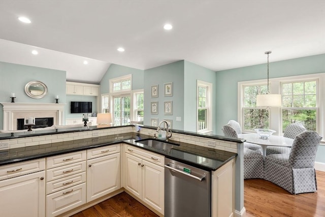 kitchen with stainless steel dishwasher, wood finished floors, a sink, open floor plan, and recessed lighting