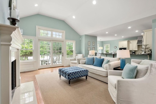 living room featuring light wood-type flooring, a fireplace, a wealth of natural light, and recessed lighting