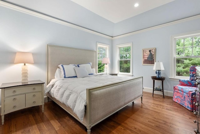 bedroom with wood finished floors, crown molding, and baseboards