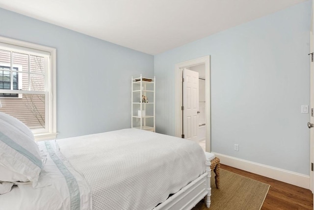 bedroom with wood finished floors and baseboards