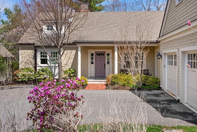 doorway to property featuring a chimney and a shingled roof