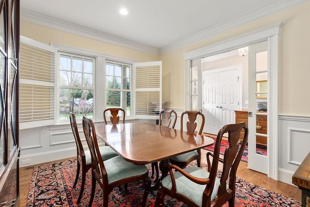 dining area with recessed lighting, a wainscoted wall, ornamental molding, a decorative wall, and light wood-style flooring