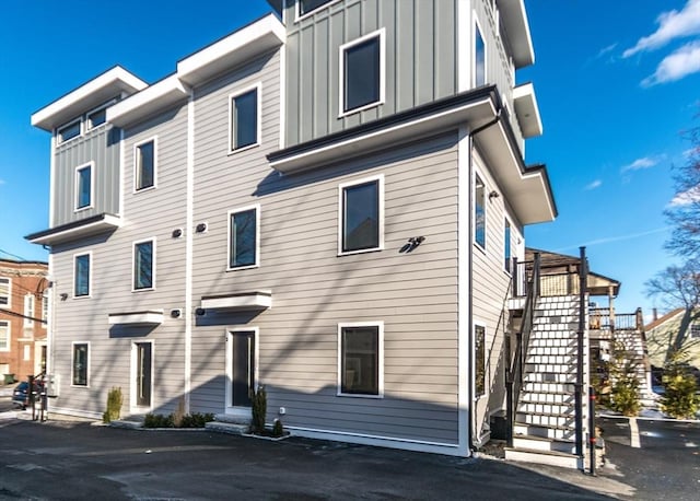 exterior space with board and batten siding, stairs, and entry steps