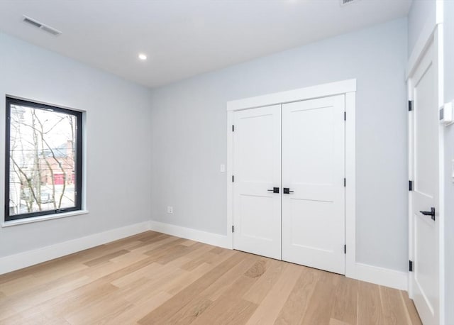 unfurnished bedroom with visible vents, a closet, baseboards, recessed lighting, and light wood-type flooring